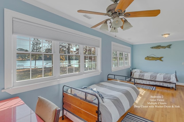 bedroom with hardwood / wood-style flooring, ceiling fan, and ornamental molding