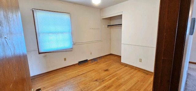 unfurnished bedroom with light wood-type flooring and a closet