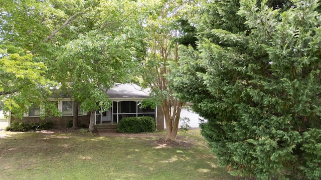 203 Lampkintown Rd, Burgess, VA 22432 - view of front of property with brick siding, a front lawn, and a sunroom