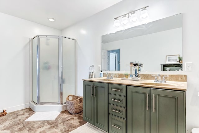 bathroom featuring a shower stall, double vanity, and a sink