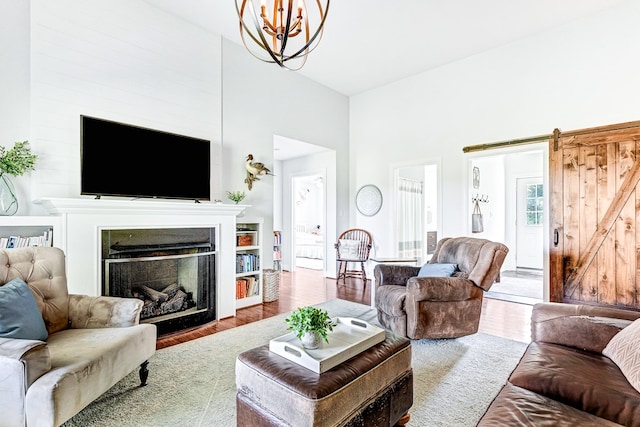 living room featuring a fireplace, a notable chandelier, and wood finished floors