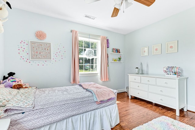 bedroom with visible vents, baseboards, a ceiling fan, and wood finished floors