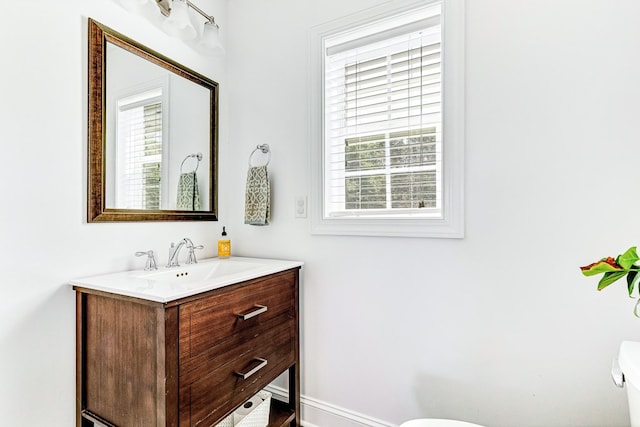 bathroom with vanity, toilet, and baseboards