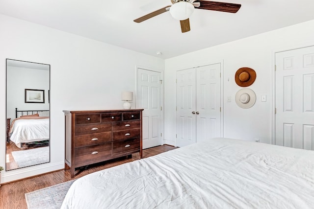 bedroom featuring a ceiling fan, wood finished floors, a closet, and baseboards