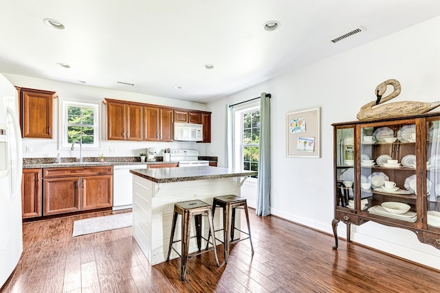 kitchen with white appliances, a healthy amount of sunlight, and dark wood-style flooring