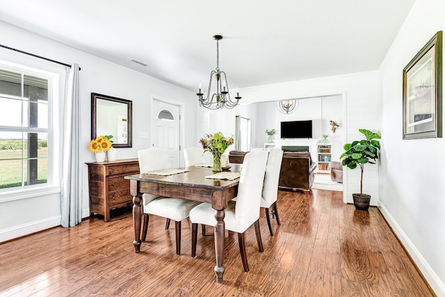 dining area with visible vents, baseboards, a notable chandelier, and wood finished floors