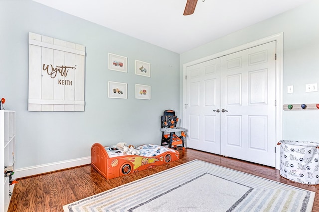 bedroom featuring a closet, ceiling fan, baseboards, and wood finished floors