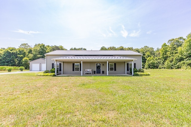 rear view of house featuring a garage, a lawn, and a porch