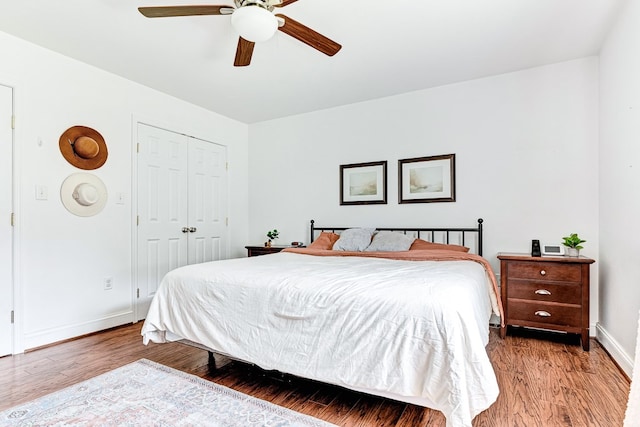 bedroom with a closet, a ceiling fan, light wood-type flooring, and baseboards