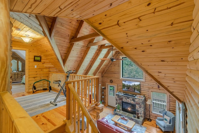 living room featuring log walls, vaulted ceiling with beams, light hardwood / wood-style floors, and wooden ceiling