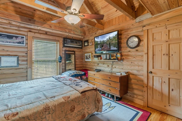 bedroom featuring wooden ceiling, hardwood / wood-style flooring, ceiling fan, rustic walls, and beamed ceiling