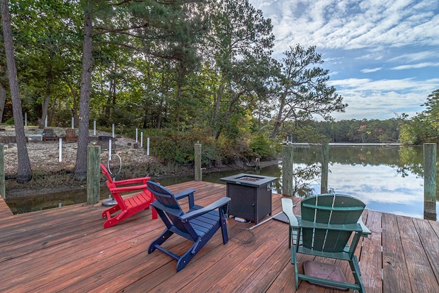 deck with a water view and an outdoor fire pit