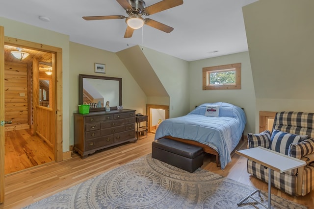 bedroom featuring light wood-type flooring, rustic walls, and ceiling fan