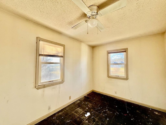 empty room with ceiling fan and a textured ceiling