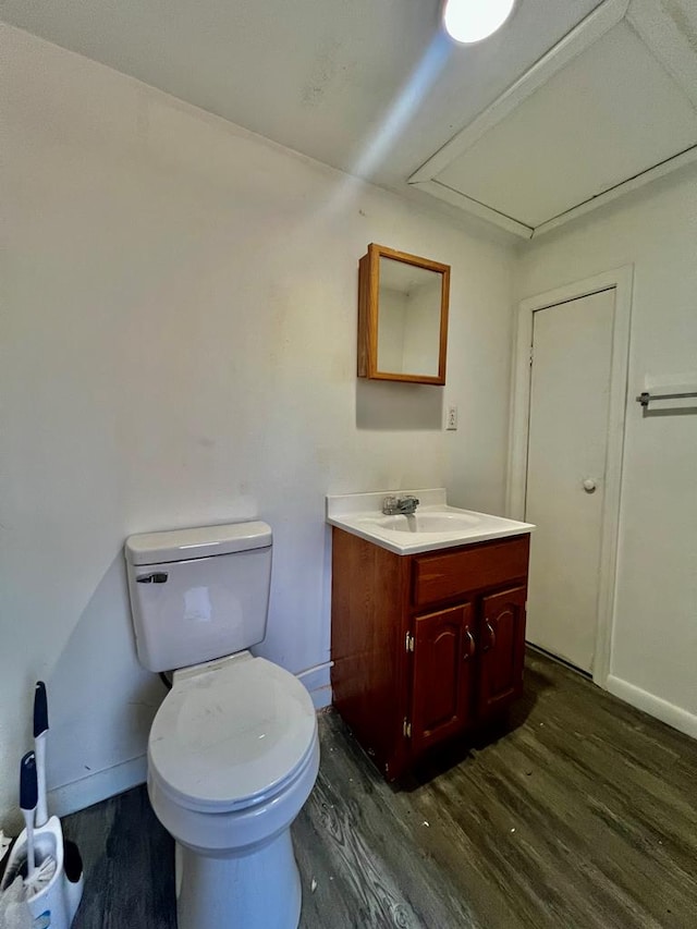 bathroom featuring toilet, vanity, and hardwood / wood-style flooring