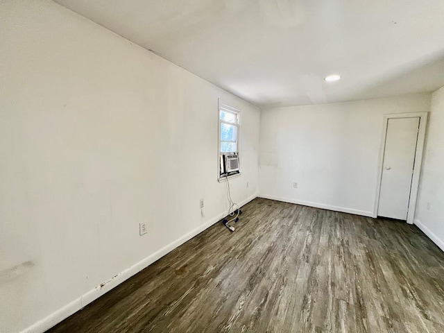 unfurnished room with cooling unit and dark wood-type flooring