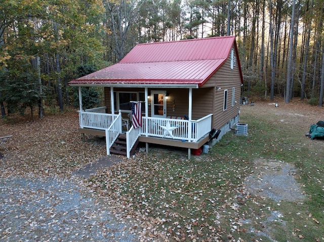 view of front facade with covered porch and central AC