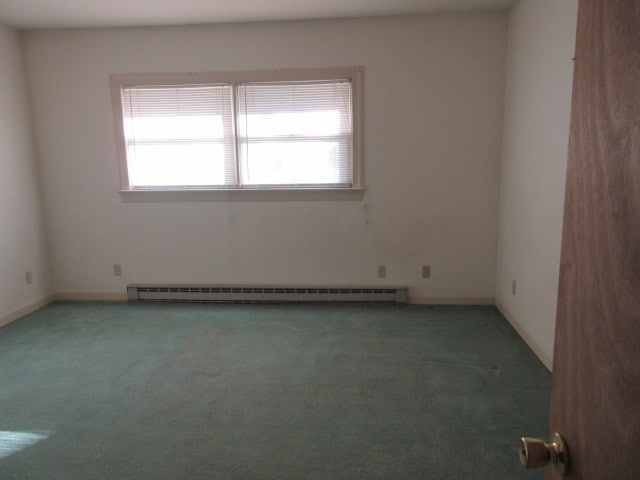 carpeted empty room featuring plenty of natural light and baseboard heating