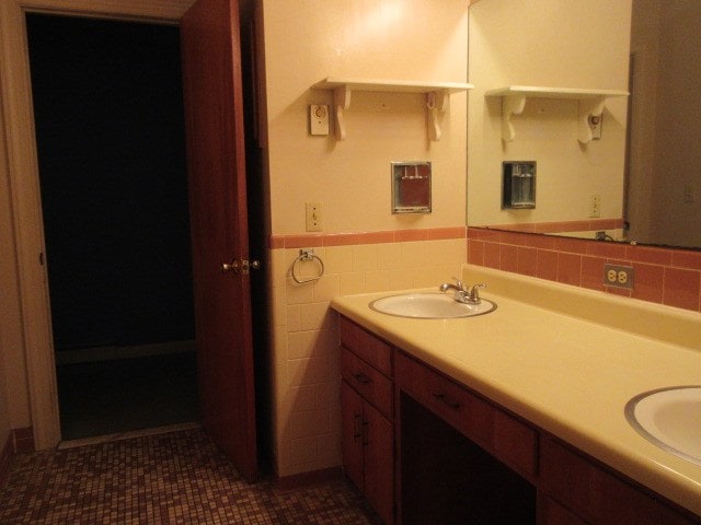 bathroom with tile patterned flooring, vanity, and tile walls