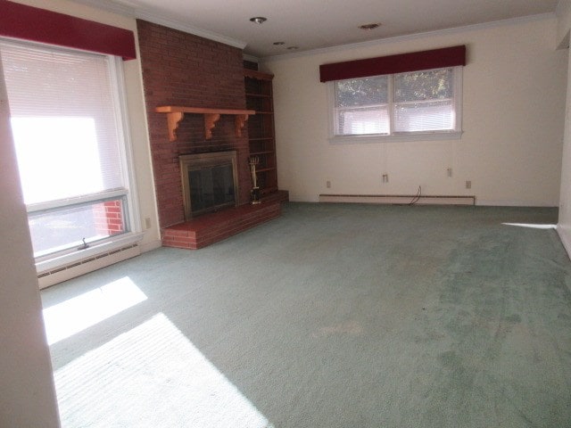 unfurnished living room with crown molding, a fireplace, carpet floors, and a baseboard heating unit