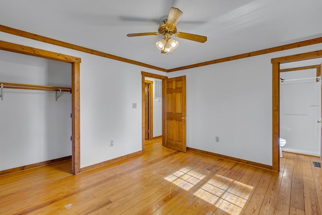 unfurnished bedroom featuring light wood-style floors, a closet, ensuite bath, a ceiling fan, and baseboards