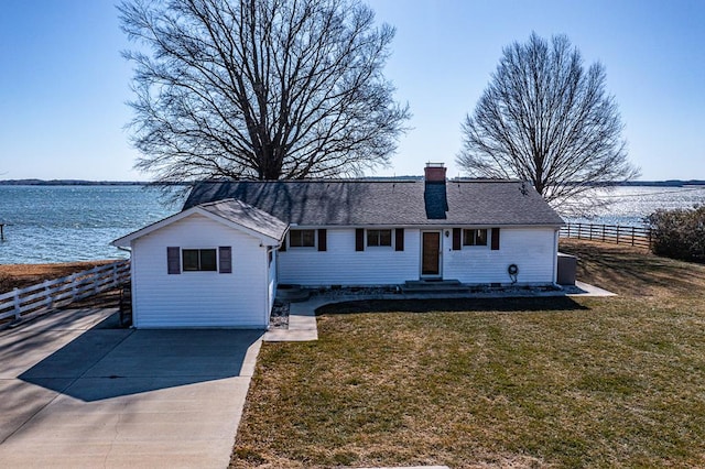 single story home with a water view and a front lawn