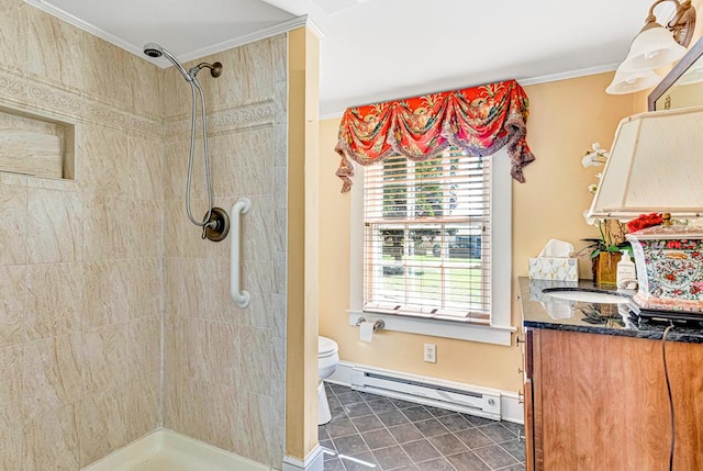 bathroom with vanity, toilet, baseboard heating, and a tile shower