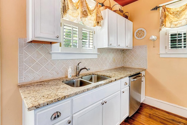 kitchen featuring white cabinets, stainless steel dishwasher, sink, and hardwood / wood-style floors