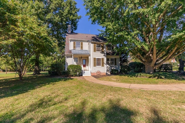 colonial inspired home featuring a front lawn