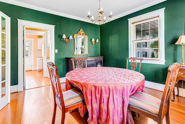 dining space featuring a notable chandelier, wood-type flooring, and ornamental molding