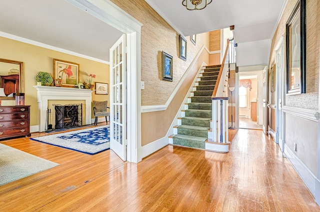 foyer entrance with hardwood / wood-style flooring and crown molding