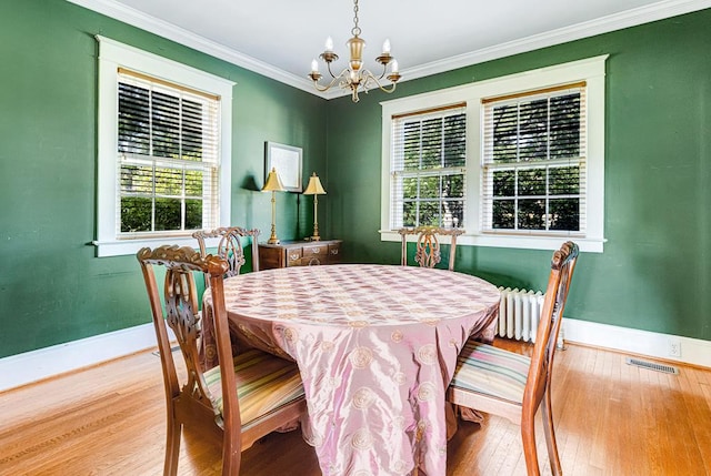 dining room featuring hardwood / wood-style floors, a notable chandelier, crown molding, and a wealth of natural light