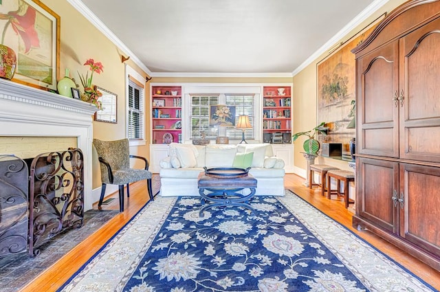 living area featuring built in shelves, a brick fireplace, dark wood-type flooring, and crown molding