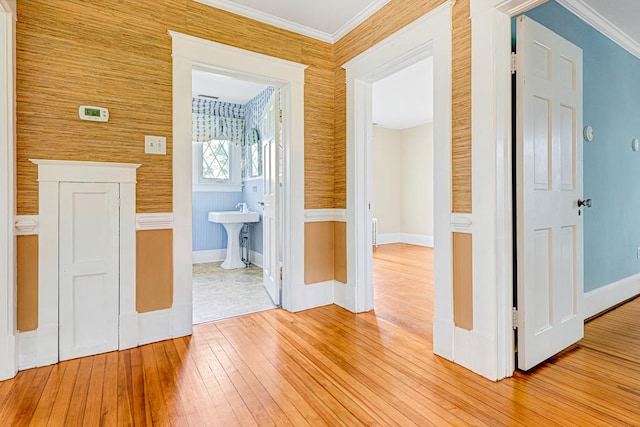 corridor featuring light hardwood / wood-style floors, sink, and crown molding