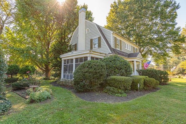 view of side of property featuring a sunroom and a yard