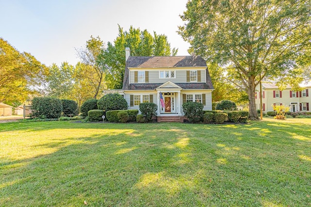 colonial-style house featuring a front lawn