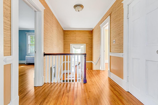 corridor with radiator, crown molding, and wood-type flooring