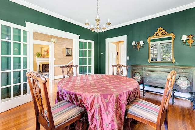 dining area with hardwood / wood-style flooring, a notable chandelier, and crown molding