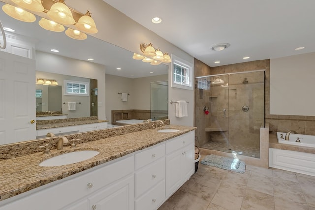 full bath with a sink, a shower stall, double vanity, and a garden tub
