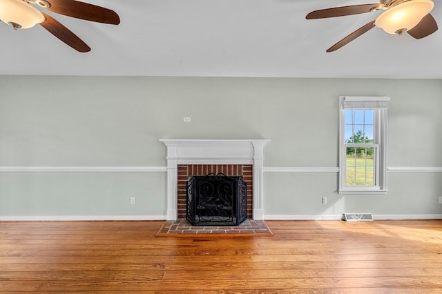 unfurnished living room with hardwood / wood-style floors, a fireplace, and ceiling fan