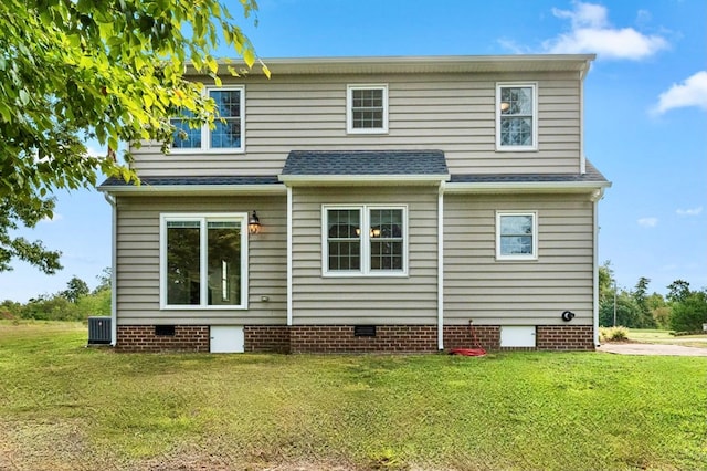 back of house with cooling unit and a yard