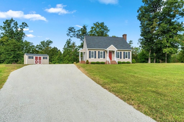 new england style home with a storage shed and a front yard