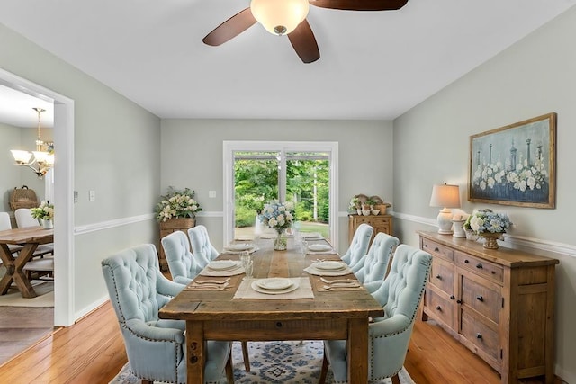 dining area featuring ceiling fan with notable chandelier and light hardwood / wood-style floors