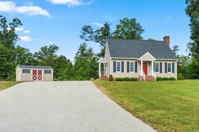 view of front of home with a storage unit and a front lawn