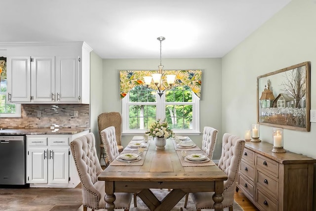 dining area with an inviting chandelier, dark wood-type flooring, and a healthy amount of sunlight