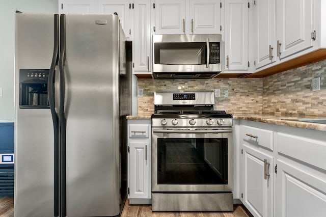 kitchen with white cabinetry, appliances with stainless steel finishes, light hardwood / wood-style floors, and backsplash