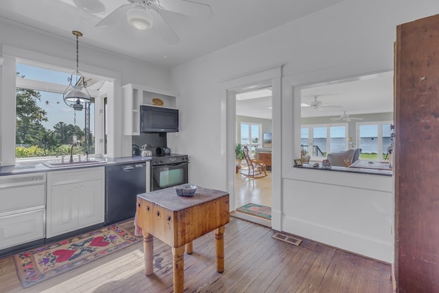 kitchen with black appliances, decorative light fixtures, sink, and a wealth of natural light