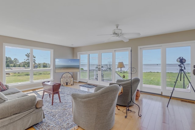 living room featuring ceiling fan, light wood-type flooring, and french doors