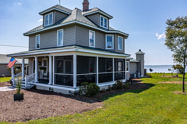 exterior space with a water view and a front lawn