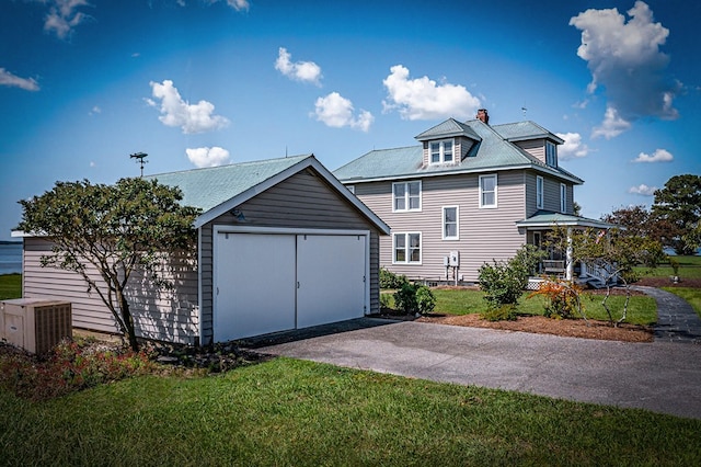 rear view of property with an outbuilding, a yard, central AC, and covered porch